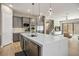 Spacious kitchen with stainless appliances and a waterfall island, seamlessly flowing into the living area at 6433 Farness St, Las Vegas, NV 89135
