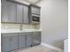 Gray kitchenette equipped with stainless steel microwave, refrigerator, and sink for modern convenience at 6433 Farness St, Las Vegas, NV 89135