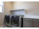 Modern laundry room with front-load washer and dryer, storage cabinets, and a countertop for convenience at 6433 Farness St, Las Vegas, NV 89135