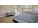 Bright main bedroom with a bed, gray sofa, and door leading to the outside, perfect for a relaxing retreat at 6433 Farness St, Las Vegas, NV 89135