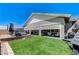 Expansive backyard featuring a hot tub, lush green lawn, and outdoor living space at 689 Moonstone Beach Pl, Henderson, NV 89011