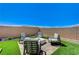 Outdoor seating area with modern chairs arranged around a stone fire pit at 689 Moonstone Beach Pl, Henderson, NV 89011