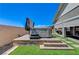 Backyard hot tub on a stone platform with green grass and access to the house at 689 Moonstone Beach Pl, Henderson, NV 89011