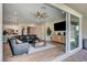 Open-concept living room with a large sectional, modern ceiling fan, and sliding doors to the outdoor patio at 689 Moonstone Beach Pl, Henderson, NV 89011