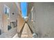 Narrow side yard with a stone pathway between two homes, leading to a gate at 689 Moonstone Beach Pl, Henderson, NV 89011