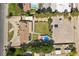 Aerial shot showcasing the property's layout including a pool, lawn, sheds, and lush landscaping at 7350 W Rome Blvd, Las Vegas, NV 89131