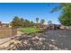 A serene backyard featuring a grassy lawn, a deck, mature trees, and a small shed at 7350 W Rome Blvd, Las Vegas, NV 89131