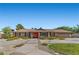 Single-story home with a vibrant orange front door, wide driveway, and a well-kept lawn at 7350 W Rome Blvd, Las Vegas, NV 89131