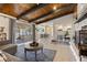 Open-concept living room with fireplace, wood-beamed ceilings, and dining area at 7350 W Rome Blvd, Las Vegas, NV 89131
