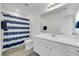 Well-lit bathroom features a vanity, mirror and shower with blue and white striped shower curtain at 7361 Ringquist St, Las Vegas, NV 89148