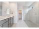 Modern bathroom featuring double sink vanity and a glass-enclosed shower with neutral tile at 789 Black Palace St, Henderson, NV 89011
