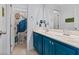 Bathroom vanity with double sinks, blue cabinets, and a large mirror at 8566 Burning Bridge Ct, Las Vegas, NV 89131