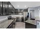 Well-equipped kitchen with granite countertops, dark wood cabinets and modern stainless steel appliances at 8566 Burning Bridge Ct, Las Vegas, NV 89131
