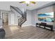 Spacious living room with a staircase, wood floors, and a large wall-mounted TV at 8566 Burning Bridge Ct, Las Vegas, NV 89131
