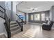 Bright, open living room with wood floors, a ceiling fan, and large windows providing natural light at 8566 Burning Bridge Ct, Las Vegas, NV 89131