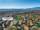 Wide aerial view of the golf course community with lakes and mountain views at 8848 Rainbow Ridge Dr, Las Vegas, NV 89117