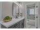 Bathroom with marble countertops, dark cabinets, and a glass-enclosed shower at 8848 Rainbow Ridge Dr, Las Vegas, NV 89117