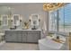 Modern bathroom featuring a soaking tub, dual sinks, marble counters, and natural light at 8848 Rainbow Ridge Dr, Las Vegas, NV 89117