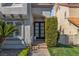 Elegant front entrance with a modern glass door, complemented by manicured landscaping and mature plants at 8848 Rainbow Ridge Dr, Las Vegas, NV 89117