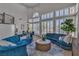 Bright living room with vaulted ceilings, plantation shutters, hardwood floors, and stylish blue seating at 8848 Rainbow Ridge Dr, Las Vegas, NV 89117