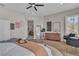 Bright main bedroom featuring wood floors, a ceiling fan, and access to an outdoor balcony and primary bath at 8848 Rainbow Ridge Dr, Las Vegas, NV 89117