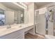 Well-lit bathroom featuring a vanity with a sink, a large mirror, and a glass door shower at 9124 Sapphire Ridge Ave, Las Vegas, NV 89129