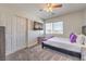 Comfortable bedroom offering a full-size bed, a ceiling fan, carpet, and a mounted TV at 9124 Sapphire Ridge Ave, Las Vegas, NV 89129