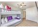 Cozy bedroom showcasing a bunk bed with decorative pillows, a ceiling fan, and wood-look flooring at 9124 Sapphire Ridge Ave, Las Vegas, NV 89129