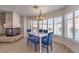 Dining room with modern chandelier, fireplace, plantation shutters, and view of the backyard at 9124 Sapphire Ridge Ave, Las Vegas, NV 89129