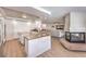 Open-concept kitchen with granite countertops, white cabinetry, and a view of the living area and fireplace at 9124 Sapphire Ridge Ave, Las Vegas, NV 89129