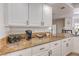Bright kitchen counter with granite countertops, white cabinets, and modern appliances, creating a cozy atmosphere at 9124 Sapphire Ridge Ave, Las Vegas, NV 89129