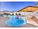 Sparkling swimming pool and spa adorned with a pink flamingo float under a clear blue sky at 9124 Sapphire Ridge Ave, Las Vegas, NV 89129