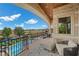Luxurious balcony with stone accents, pool view, and comfortable seating area at 9301 Verlaine Ct, Las Vegas, NV 89145