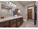 Bright bathroom features a large mirror, modern vanity, and neutral tile flooring at 9301 Verlaine Ct, Las Vegas, NV 89145