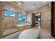 Serene bathroom featuring a soaking tub, walk-in shower, and picturesque views creating a peaceful retreat at 9301 Verlaine Ct, Las Vegas, NV 89145