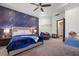 Bedroom with navy accent wall, ceiling fan, king-size bed, and neutral décor at 9301 Verlaine Ct, Las Vegas, NV 89145