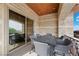 Covered patio with a stone arch, wood ceiling, and dining table with seating for six at 9301 Verlaine Ct, Las Vegas, NV 89145