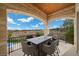 Covered patio featuring stone arches, wrought iron railing, dining table and panoramic views at 9301 Verlaine Ct, Las Vegas, NV 89145