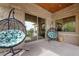 Covered patio features stone walls, hanging chairs, and sliding glass doors to interior at 9301 Verlaine Ct, Las Vegas, NV 89145