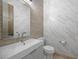 Modern powder room with a floating vanity, marble countertop, and tile accent wall at 9301 Verlaine Ct, Las Vegas, NV 89145
