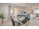 Dining area with a glass table and black chairs open to kitchen and living areas at 9326 Noble Sage Ave, Las Vegas, NV 89148