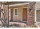 Close-up of the front door featuring a stone-accented facade and colorful plants at 9326 Noble Sage Ave, Las Vegas, NV 89148