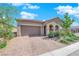 Stunning house with desert landscaping, a two-car garage, and an inviting, arched entryway at 9590 Smiley Creek St, Las Vegas, NV 89178