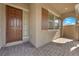 Inviting front porch featuring brick pavers, a wooden front door, and decorative shutters at 9590 Smiley Creek St, Las Vegas, NV 89178