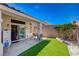 Backyard patio area with artificial turf, seating, and access to the sliding glass door at 9724 Canyon Walk Ave, Las Vegas, NV 89147