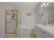 Updated bathroom with a glass-enclosed shower, and bathtub with double sinks at 9724 Canyon Walk Ave, Las Vegas, NV 89147