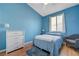 Inviting blue bedroom featuring a comfortable bed and a view of the outdoors at 9724 Canyon Walk Ave, Las Vegas, NV 89147