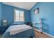 Blue bedroom with window, furnishings and light wood floor at 9724 Canyon Walk Ave, Las Vegas, NV 89147