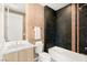 Modern bathroom with a tub and shower combination, black tiled wall, and elegant fixtures at 10752 Patina Hills Ct, Las Vegas, NV 89135