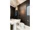 Modern powder room featuring a floating sink, decorative mirror, and textured wallpaper at 10752 Patina Hills Ct, Las Vegas, NV 89135